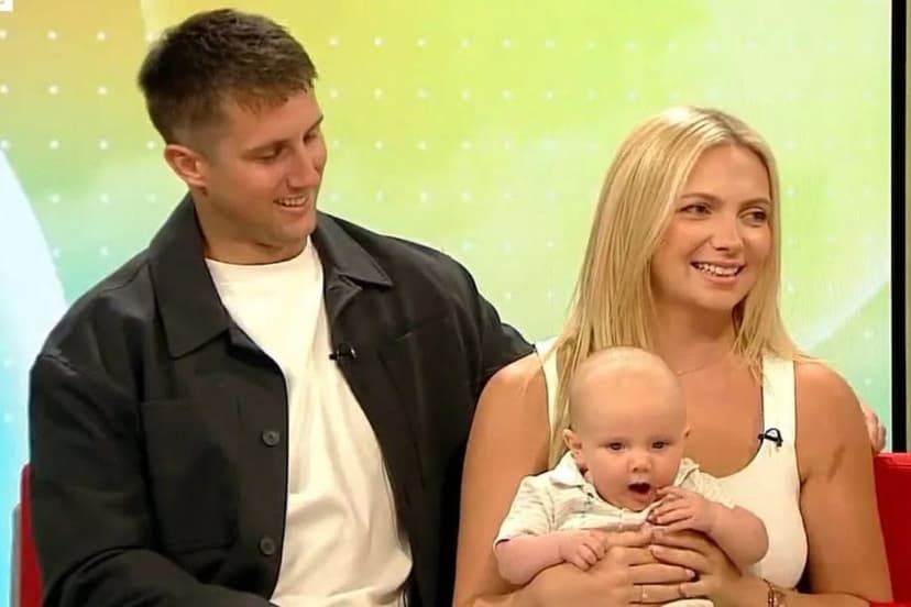 A man and woman sit on a couch for a morning television show holding their baby boy on their lap.